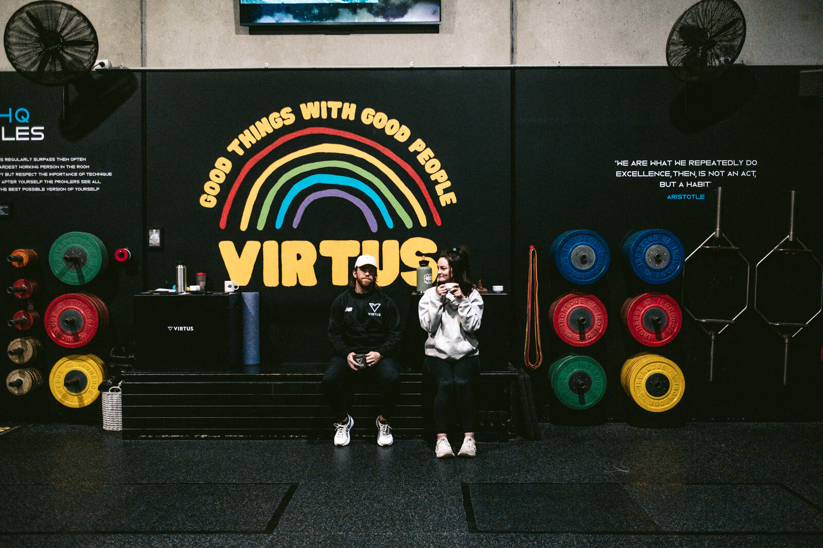 Two people relaxing together on the Virtus gym floor.